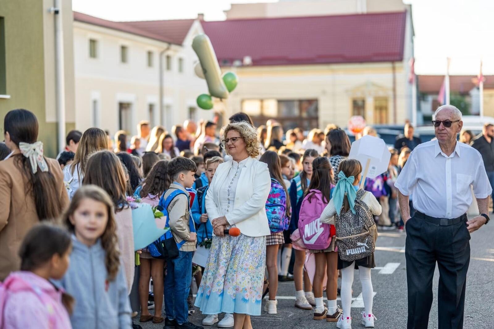 Elevi, părinți și profesori în curtea școlii la deschiderea anului școlar