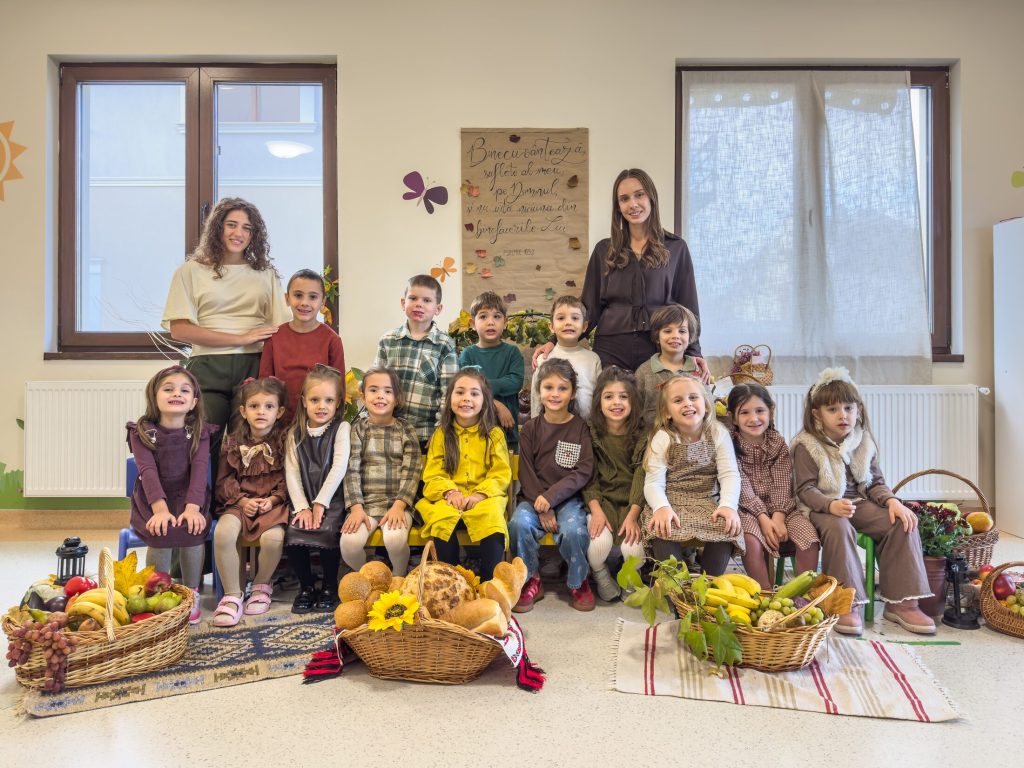 O grupă de grădiniță alături de educatoare, cu roadele toamnei